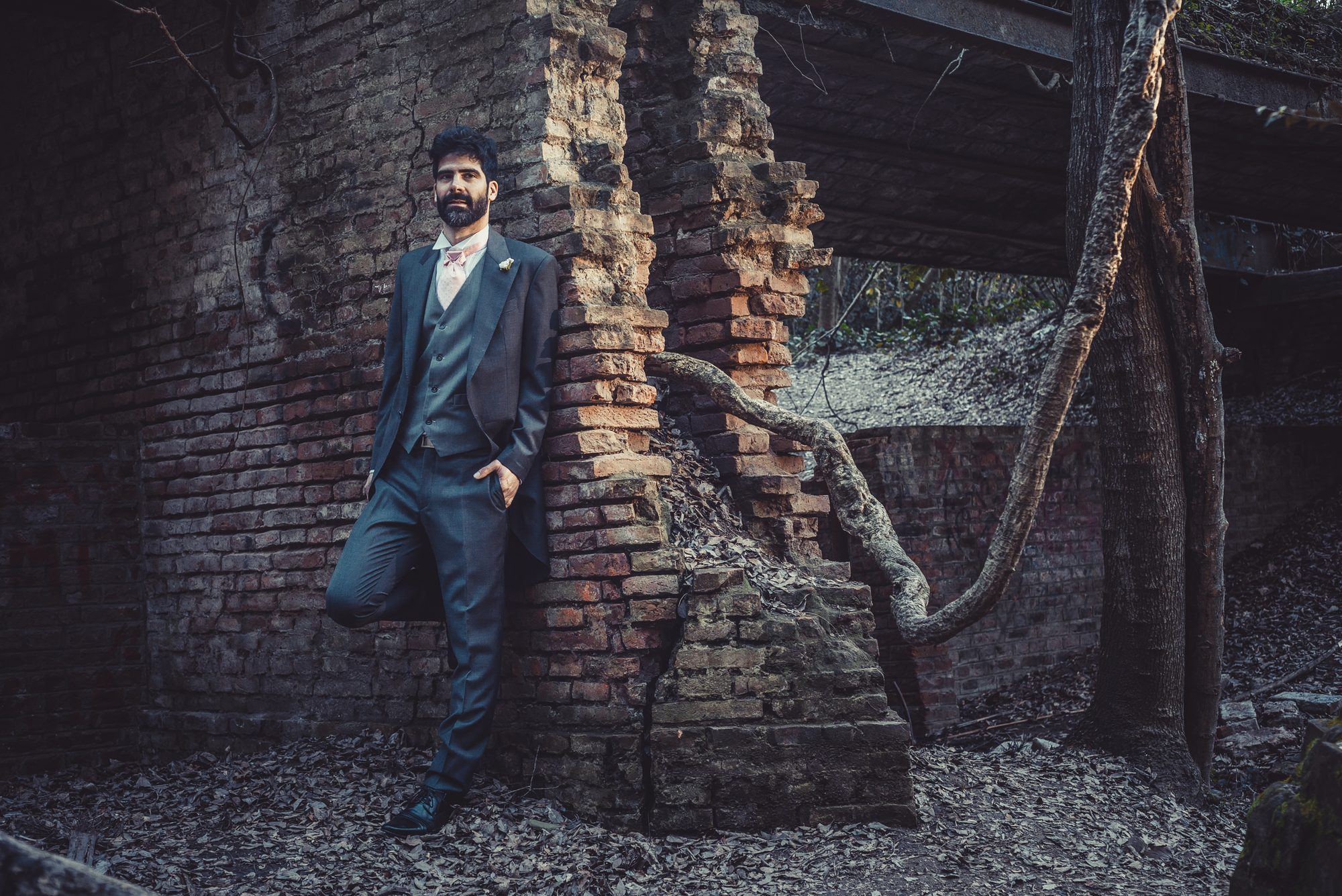 Retrato editorial de hombre de traje junto a un muro